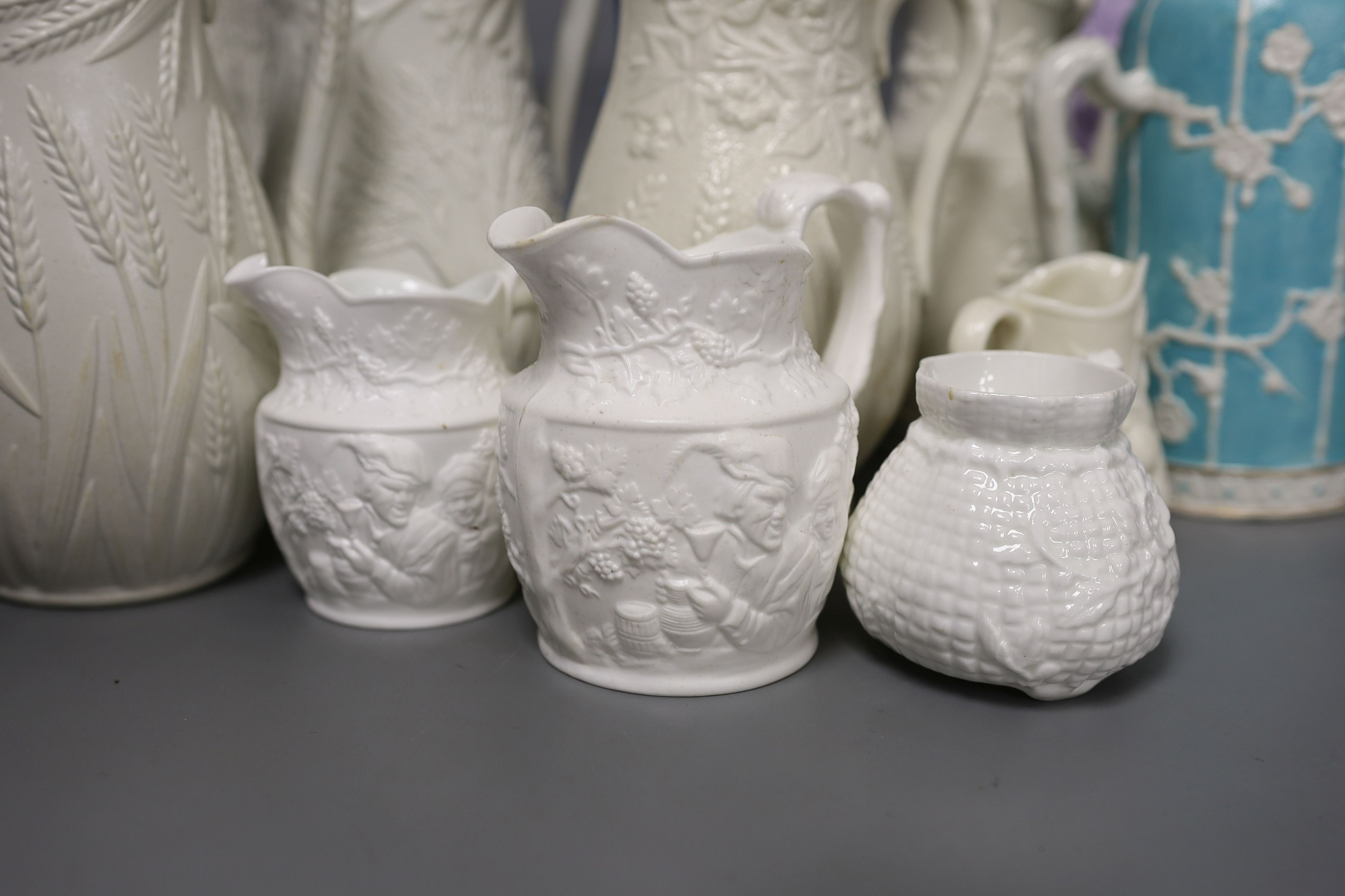 A collection of twelve Victorian relief moulded jugs